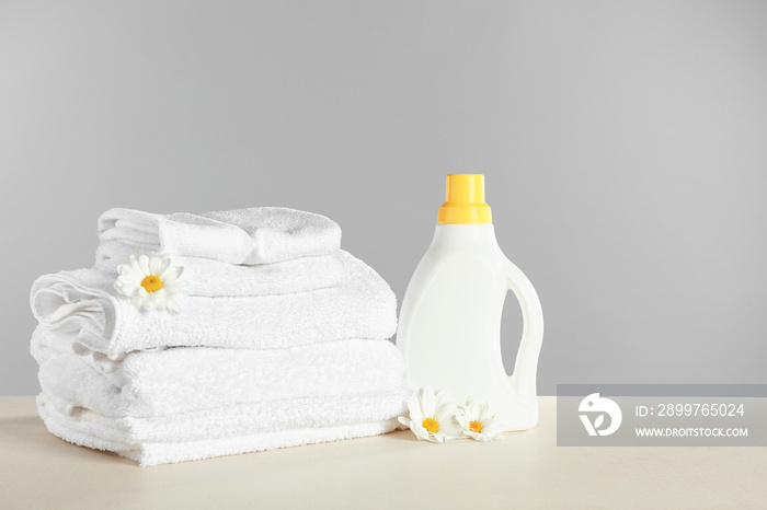 Stack of towels and laundry detergent on table