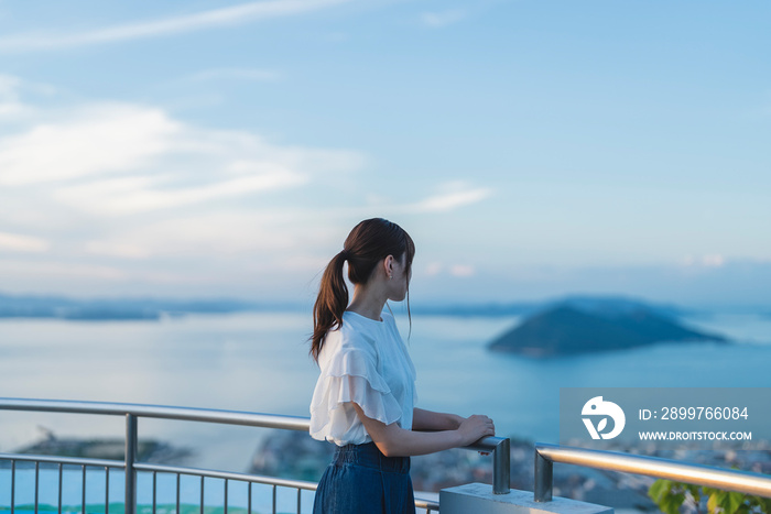 夕暮れの展望台にいる女性