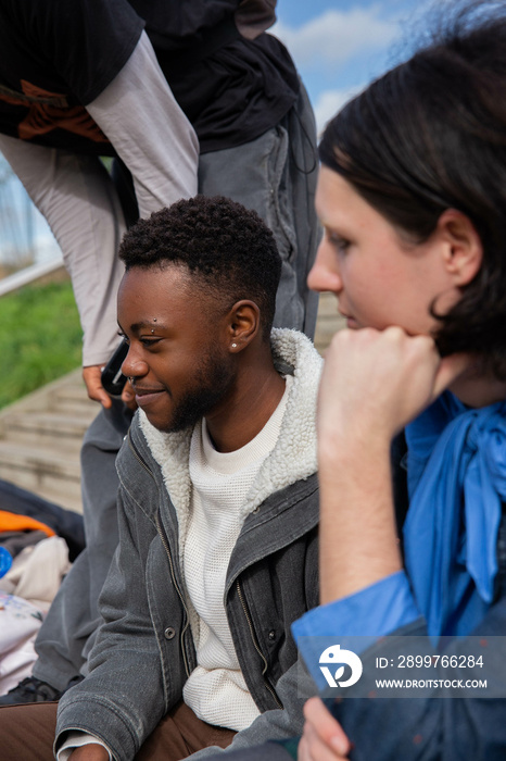 A group of trans friends chatting and sitting outside.