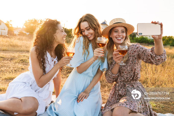 Photo of smiling nice women taking selfie photo on cellphone