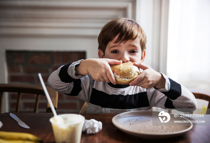 Portrait of boy (4-5) eating sandwich