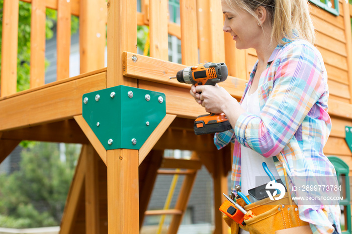 mature woman building wooden play structure