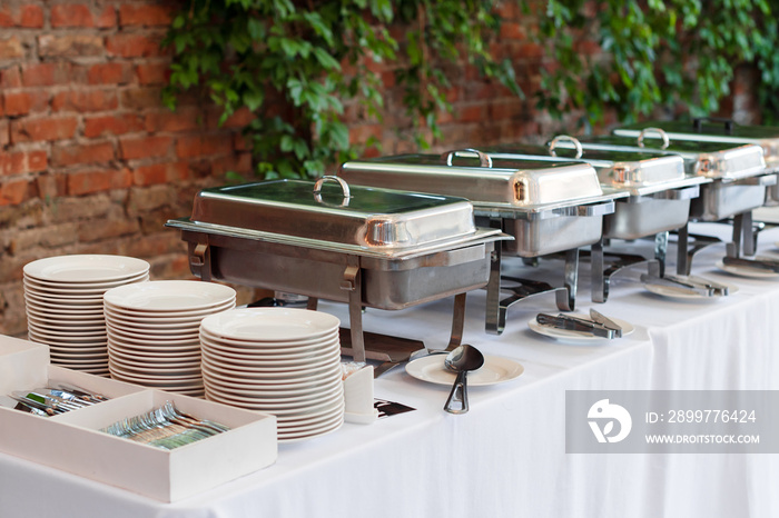 Buffet heated trays standing in line ready for service. Outdoors buffet restaurant, the hotel restau