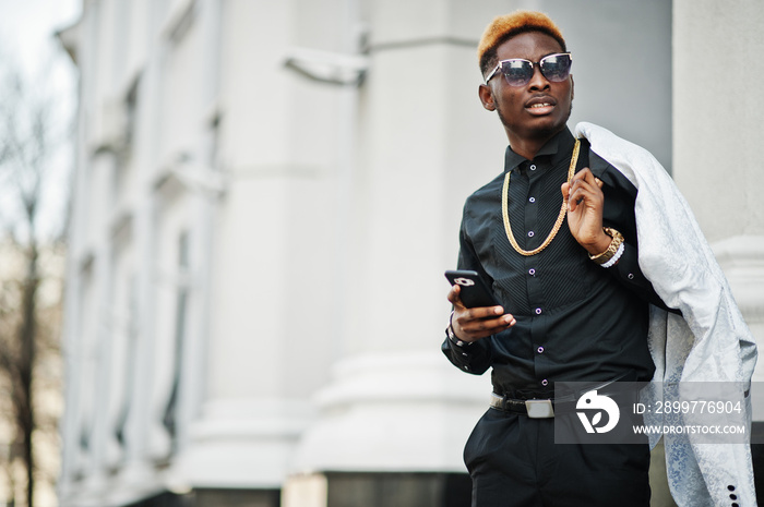 Chic handsome african american man in white suit and black shirt with mobile phone.