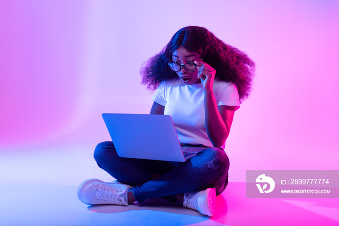 Deadline concept. Full length of surprised black woman using laptop computer, opening mouth in shock