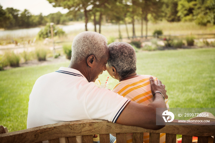 Senior couple relaxing on bench in backyard