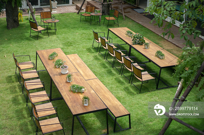 Classic wood with steel rim tables and chairs are arranged in the little garden, shot from 2nd floor