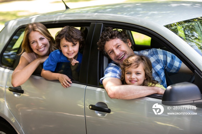 Smiling family sitting in a car