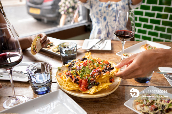 �UK, London, Close-up of friends enjoying Mexican food at restaurant table