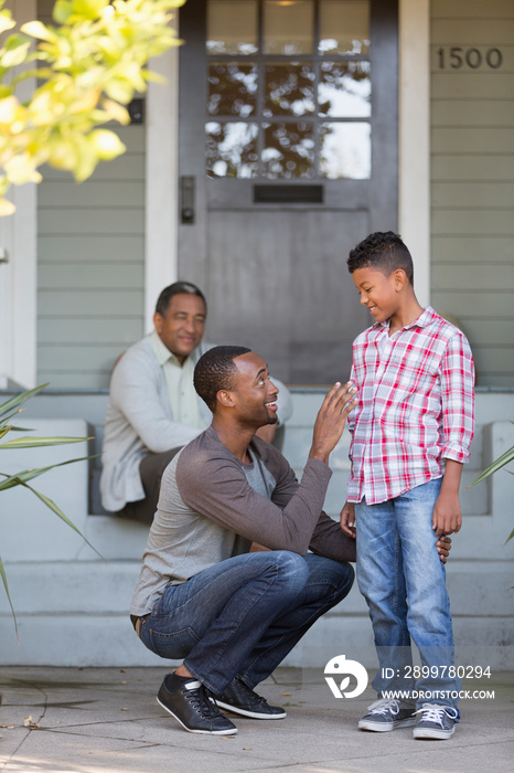 Father and son talking on front stoop