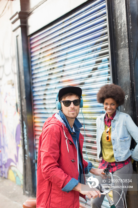 Portrait confident young man and woman near graffiti wall