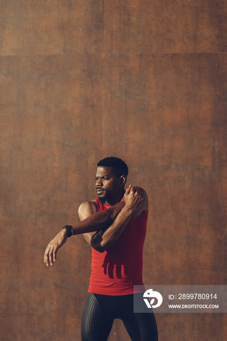 Young black man exercising against a wall