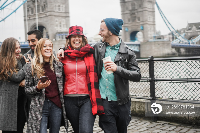 Young friends having fun outdoor at the city next Tower Bridge in London - Focus on center girl face