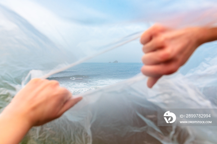 两只手打碎一个塑料袋，敢看大海。生态环境理念。