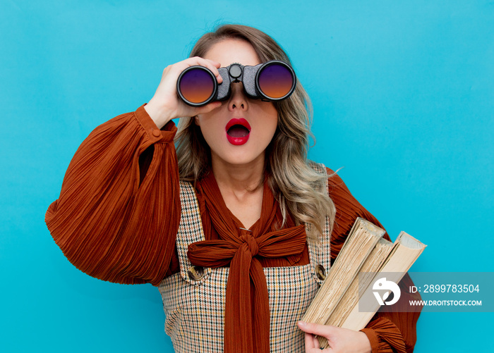 Young teacher with books and binocular