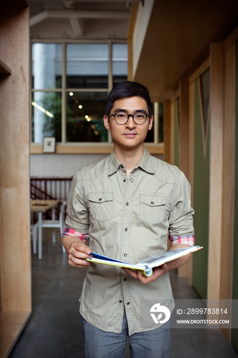 Portrait of man holding book