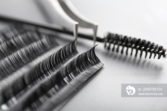 Set of eyelash extensions on grey background, closeup