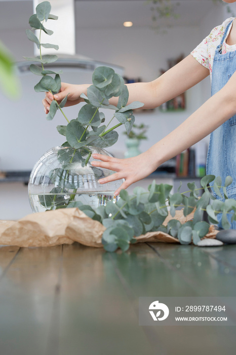 Young woman selecting foliage for vase