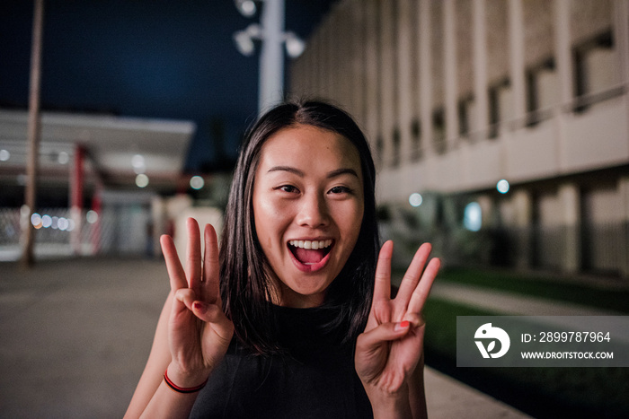 洛杉矶县艺术博物馆外一位年轻女子晚上做出令人惊叹的手势的肖像