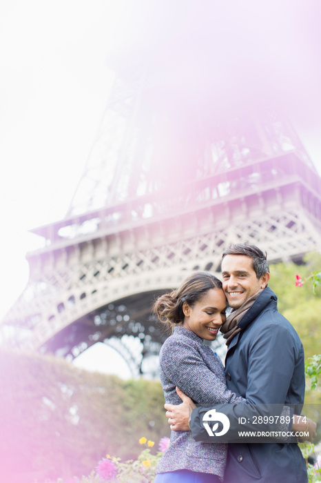 Portrait affectionate young couple hugging in front of Eiffel Tower, Paris