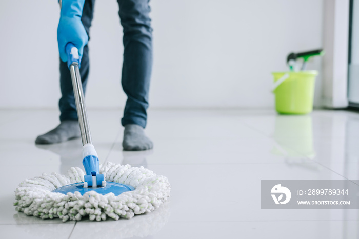 Husband housekeeping and cleaning concept, Happy young man in blue rubber gloves wiping dust using m