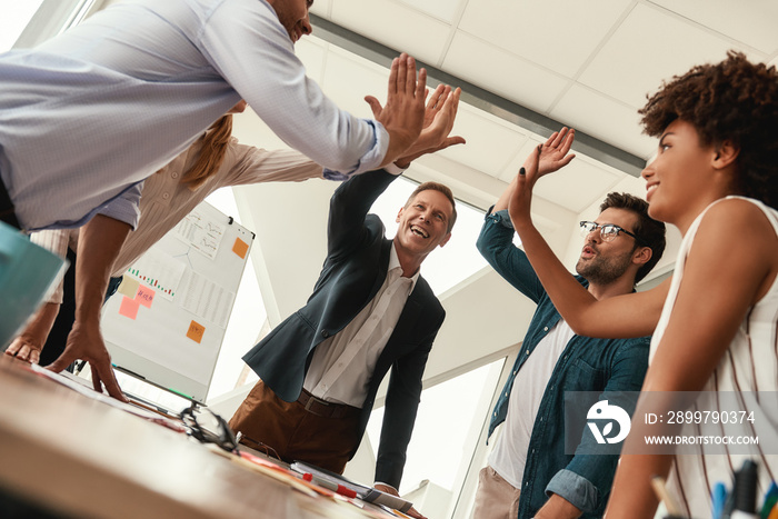 Success Business people giving each other high-five and smiling while working together in the modern