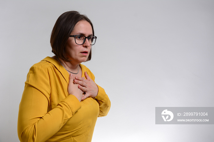 漂亮的深色头发女人在白色背景前呼吸困难。一个年轻女人抱着