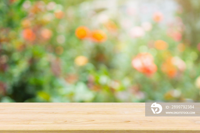 Empty wood table top with abstract blur colorful rose flowers in the garden natural bokeh light back