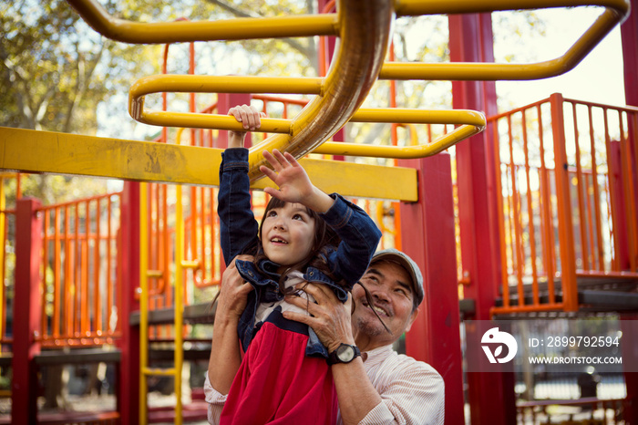 Grandfather and granddaughter (6-7) playing in playground