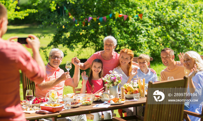 休闲、度假和人的概念-幸福的家庭享用节日晚餐或夏季花园派对