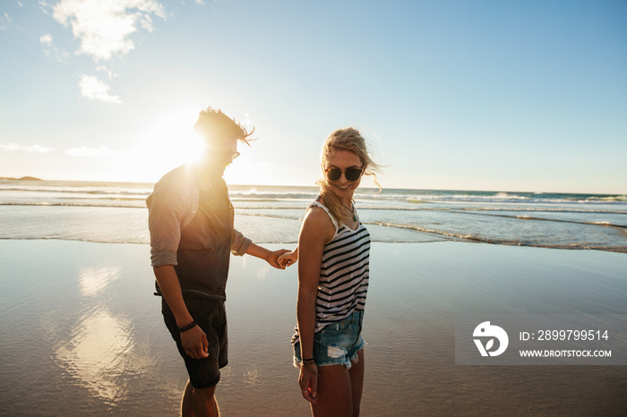 Romantic young couple walking along the sea shore