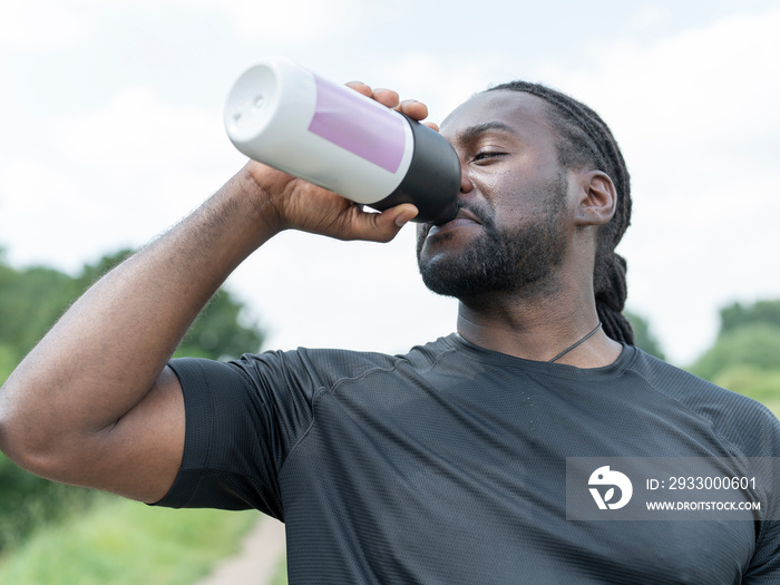 Man drinking from water bottle during workout