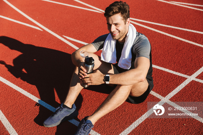 Exhausted sportsman finished running at the stadium