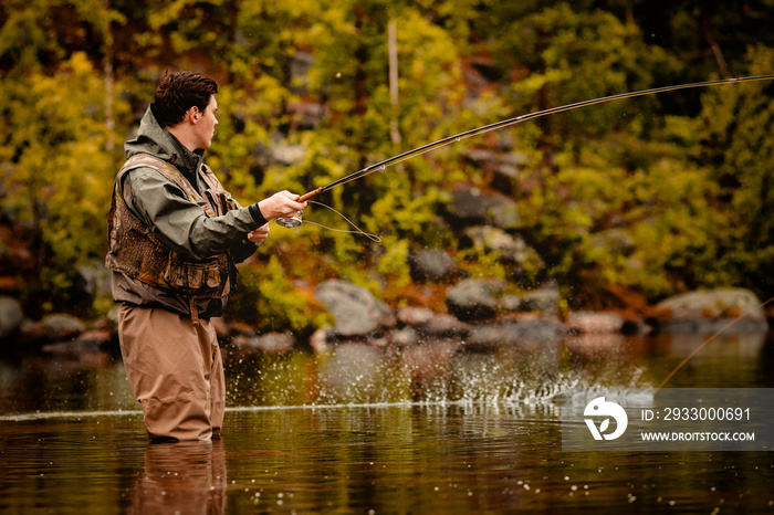 Fisherman using rod fly fishing in mountain river