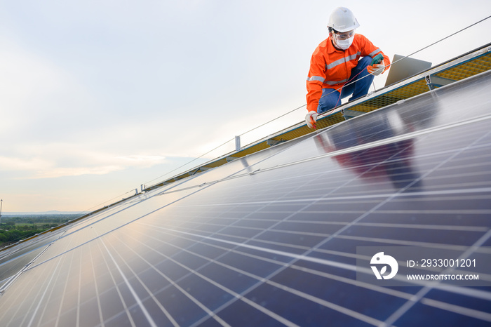 Engineers use a laptop computer to examine the solar panels at a power plant installed with solar panels using solar energy..