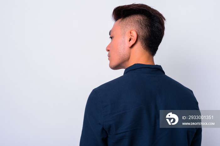 Closeup rear view of young Asian businessman looking over shoulder