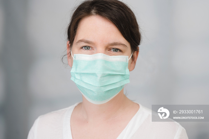 junge Frau mit medizinischem Mundschutz als Schutz vor Viren und Bakterien Covid-19 Coronavirus Maßnahmen Krankenschwester