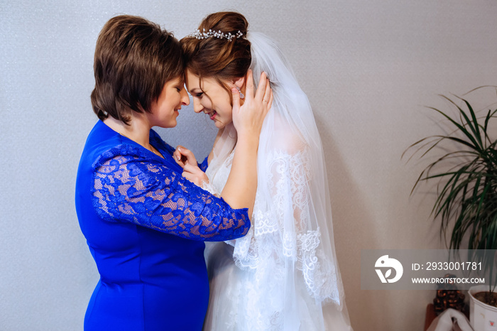 mother and her daughter the bride stands face to face against the wall