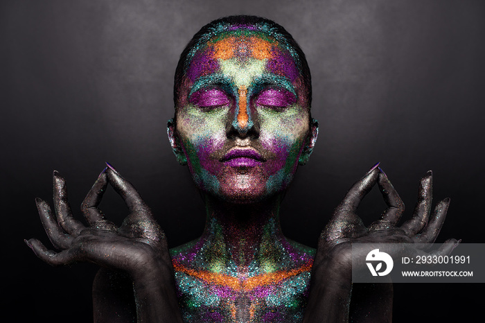 Young artistic woman in black paint and colourful powder. Glowing dark makeup. Creative body art on the theme of space and stars. Bodypainting project: art, beauty, fashion.