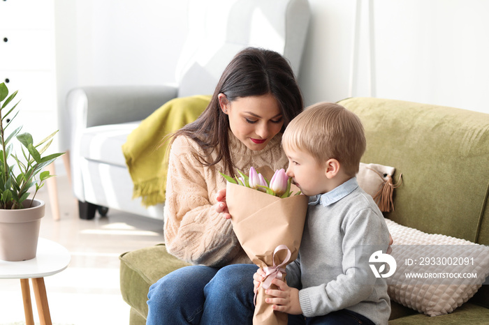 Little boy greeting his mother with 8 March at home