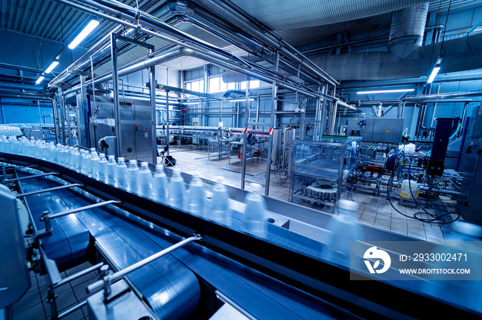 Conveyor belt with bottles of drinking water at a modern beverage plant.