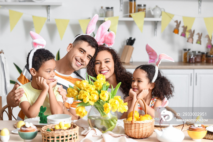 Happy family celebrating Easter at dining table in kitchen