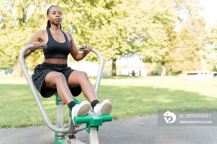 Young woman exercising in outdoor gym