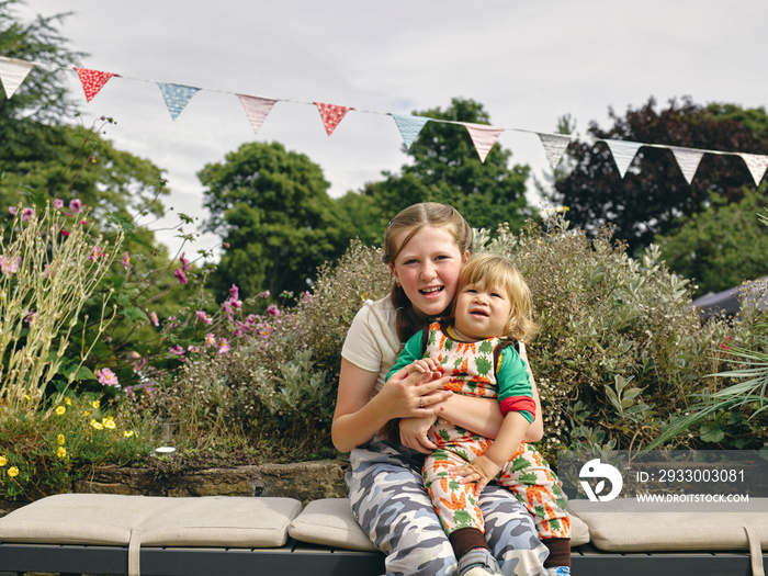 Portrait of smiling girl holding baby brother