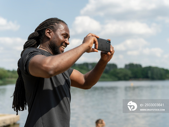 Man photographing lake with smart phone