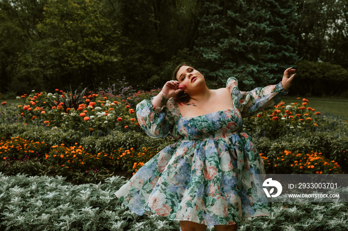 portrait of a plus size woman holding a macaron in a garden