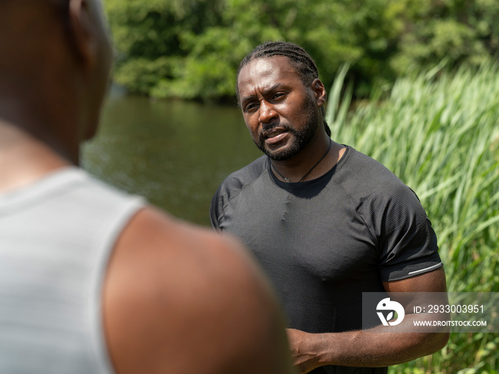 Two men talking after exercising outdoors