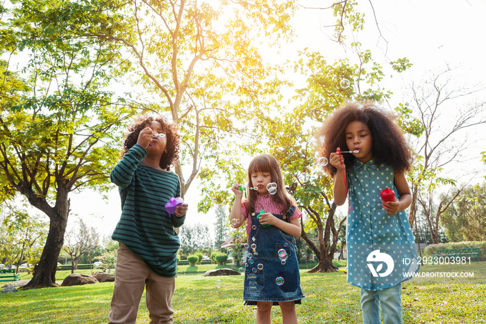 Group of children playing blowing bubbles fun