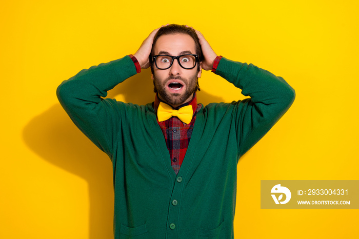 Photo of young stressed scared guy reaction touch hands head open mouth confused bad finance results confused isolated on yellow color background