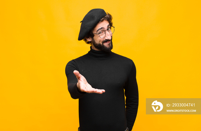 young french artist man smiling, looking happy, confident and friendly, offering a handshake to close a deal, cooperating against orange wall